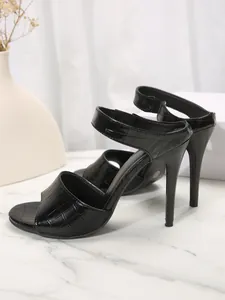 Detail of sexy black snakeskin stiletto heels with peep toe design