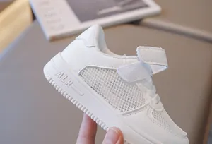 Detail view of breathable white children's mesh sneakers with secure velcro strap