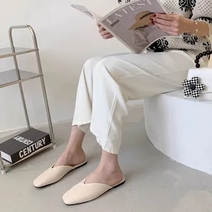 Eleganti sabot flat beige a punta presentati in un ambiente interno moderno e minimalista