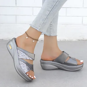 Dettaglio ravvicinato di sandali con zeppa argento metallizzato e glitter moda