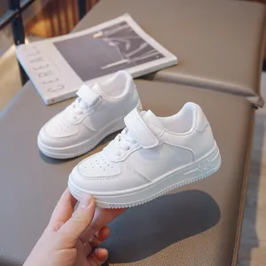 Classic all-white children's sneakers with velcro straps and breathable toe box design