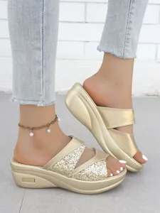 Vista dettagliata di sandali con zeppa dorati alla moda con cinturini glitterati