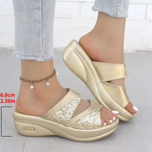 Vista dettagliata dell'altezza del tacco di 6,0 cm di questi eleganti sandali con zeppa dorati