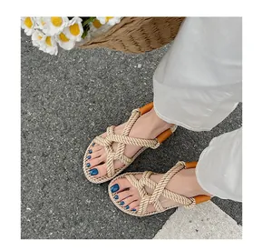 Detaillierte Draufsicht auf handgefertigte Bohème-Sandalen aus gewebtem Hanfseil auf Asphalt