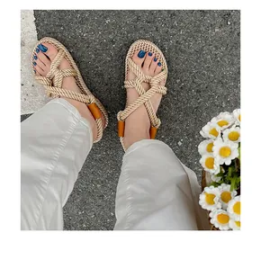 Detailaufnahme handgefertigter beiger Hanfseilsandalen kombiniert mit weißer Sommerhose
