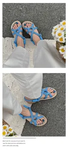 Detailansicht eleganter blauer geflochtener Römersandalen am Fuß mit Freizeitoutfit