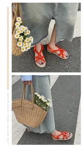 Nahaufnahme von handgefertigten orangefarbenen Seilsandalen auf der Straße.