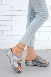 Primo piano di sandali platform argento con design a cinturino incrociato glitterato