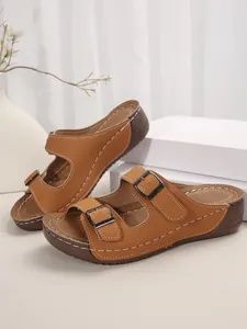 Primer plano de sandalias de plataforma marrones para mujer con tiras de hebilla doble