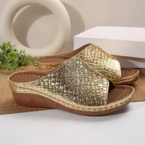 Close-up detail of luxurious golden crocodile pattern wedge slippers featuring a thick sole