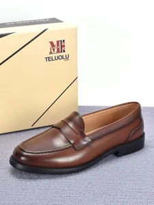 Gedetailleerd zijaanzicht van herenloafers van echt bruin leer met originele doos.
