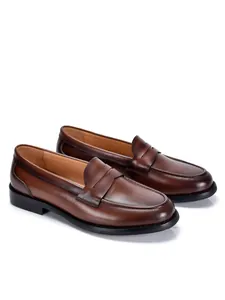 Zijaanzicht met details van klassieke bruine leren penny loafers voor heren met afwerking