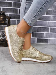 Gros plan sur des baskets à paillettes dorées pour femmes avec semelles compensées
