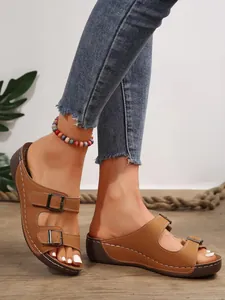 Detaillierte Nahaufnahme brauner Plateau-Sandalen mit zwei Schnallen und Nähten