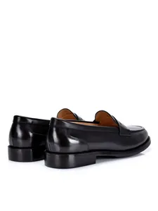 Detailweergave van klassieke zwart gepolijste lederen loafers voor heren in zakelijke stijl.