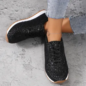 Gros plan sur des baskets noires pailletées à lacets avec semelles épaisses et bracelet