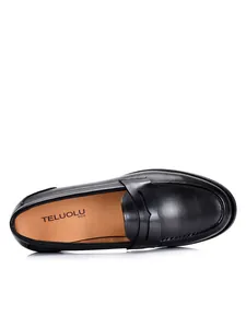 Gedetailleerd bovenaanzicht van een klassieke zwarte leren loafer met luxe lederen textuur