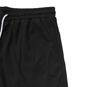 Dettaglio dei pantaloncini di velluto a coste neri da uomo con coulisse e trama del tessuto