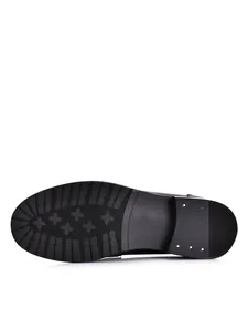 Close-up van de antislip rubberen zool van vintage zwarte leren herenloafers