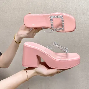 Detailed side view of pink platform slippers with rhinestones and clear straps