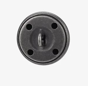 Close-up detail of the vintage brass button with a shank back and four-hole design