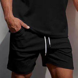 Dettaglio ravvicinato di pantaloncini sportivi in velluto nero da uomo con coulisse.