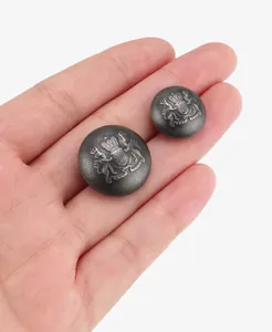 Close-up of vintage brass buttons with embossed royal lion and crown coat of arms.
