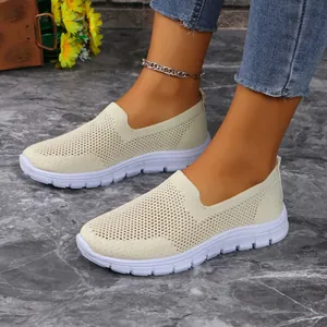 Vista laterale di sneakers slip-on in maglia beige traspirante per donna su pavimento