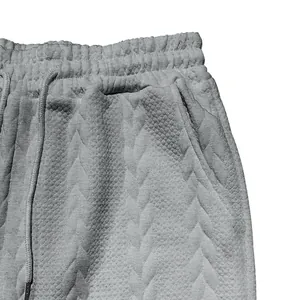 Detailansicht der grauen Herren-Freizeitshorts mit Zopfstrickmuster und elastischem Bund.