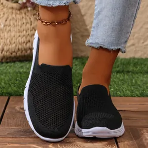 Primo piano di scarpe slip-on in maglia traspirante nera da donna per uso quotidiano