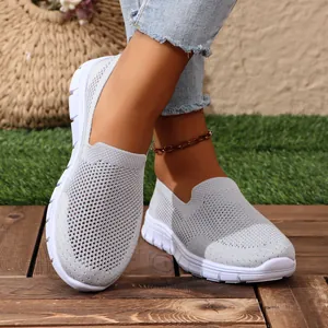 Primo piano di scarpe basse in rete grigia traspirante da donna su pavimento in legno