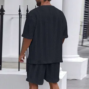 Detailansicht der Rückseite eines schwarzen Herren-Sets mit Zopfmuster, T-Shirt und Shorts