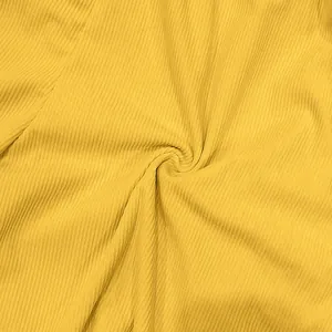 Macro-opname van gele corduroystof die de zachte geribbelde textuur en details toont.