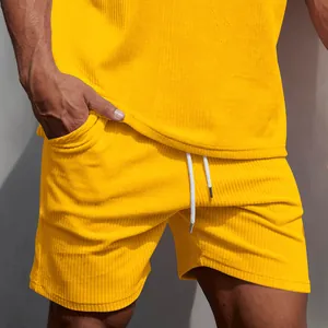 Dettaglio di pantaloncini da uomo in velluto a coste giallo con coulisse bianca.