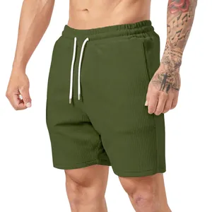 Dettaglio di pantaloncini da uomo in velluto a coste verde oliva con coulisse bianca.