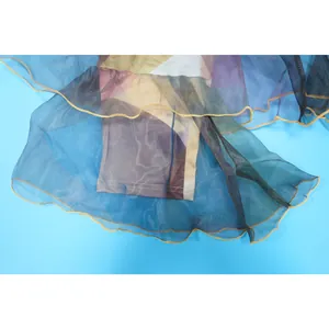 Κοντινό πλάνο παντελονιού καμπάνα tie-dye με βολάν από διάφανη οργάντζα στο τελείωμα.