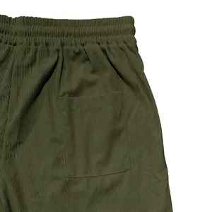 Close-up van olijfgroene corduroy stof en zakdetail op een casual herenshort