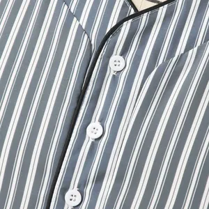 Gros plan d'un pyjama à rayures bleues et blanches avec col en V et boutons blancs.