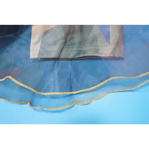Λεπτομέρεια του tie-dye καμπάνα παντελονιού με στρώση πλέγματος και χρυσό βολάν