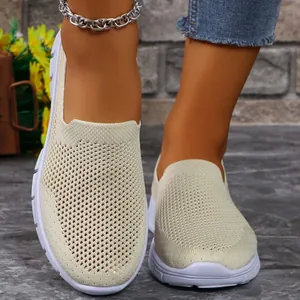 Dettaglio di sneaker slip-on in rete beige traspirante con suola comfort bianca flessibile