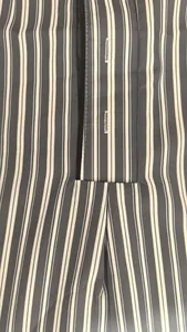 Détail rapproché du tissu à rayures verticales et de la patte de boutonnage d'une robe de chambre.