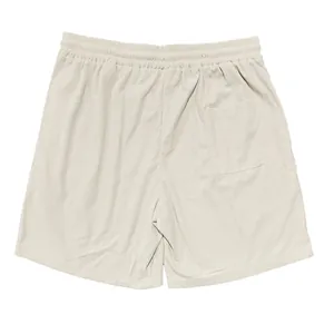 Dettaglio macro di pantaloncini di velluto a coste beige, con focus su tasca posteriore.
