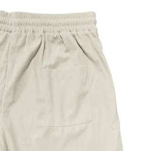 Dettaglio di pantaloncini di velluto a coste beige da uomo con elastico in vita e tasca