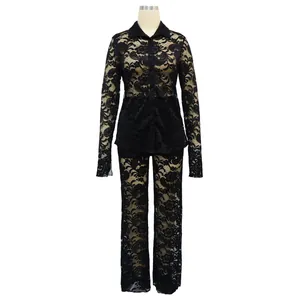 Conjunto elegante de camisa y pantalón de encaje negro transparente floral sobre un maniquí