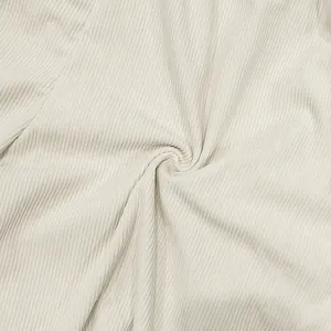 Macro dettagliata del tessuto a coste beige che mostra la texture e il drappeggio