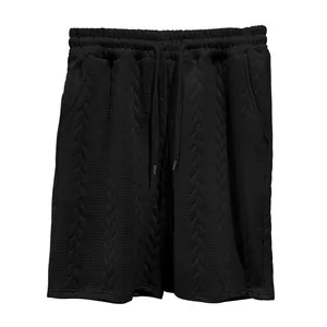 Nahaufnahme der schwarzen Herren-Shorts mit detaillierter Zopfmuster-Jacquard-Textur