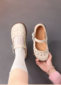 Detailansicht von beigen Mädchen-Mary-Janes aus Leder mit Blumenmustern und Spitzensocken