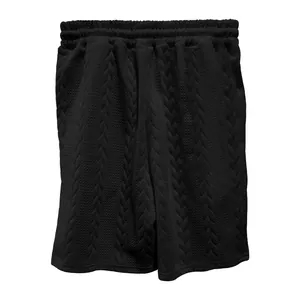 Makroansicht von schwarzen Herren-Shorts mit Zopfstrick-Jacquard-Struktur
