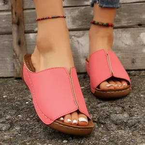 Detailed view of pink peep-toe wedge sandals featuring elegant white stitching and thick soles