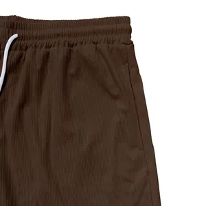 Dettaglio dei pantaloncini sportivi in velluto a coste marroni con elastico in vita